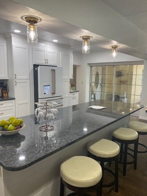 A Granite Color Island With Bar Stools