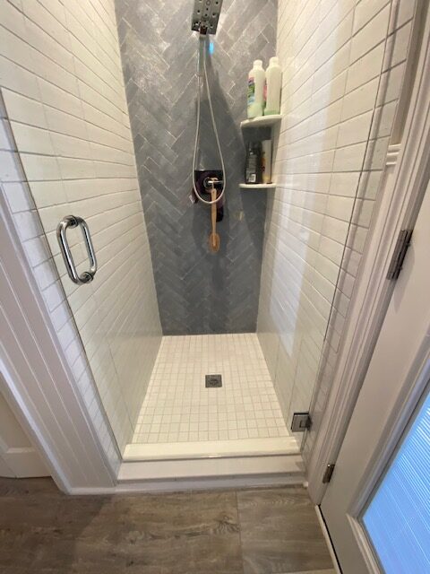 A Boxed Shower Space With White Tiles