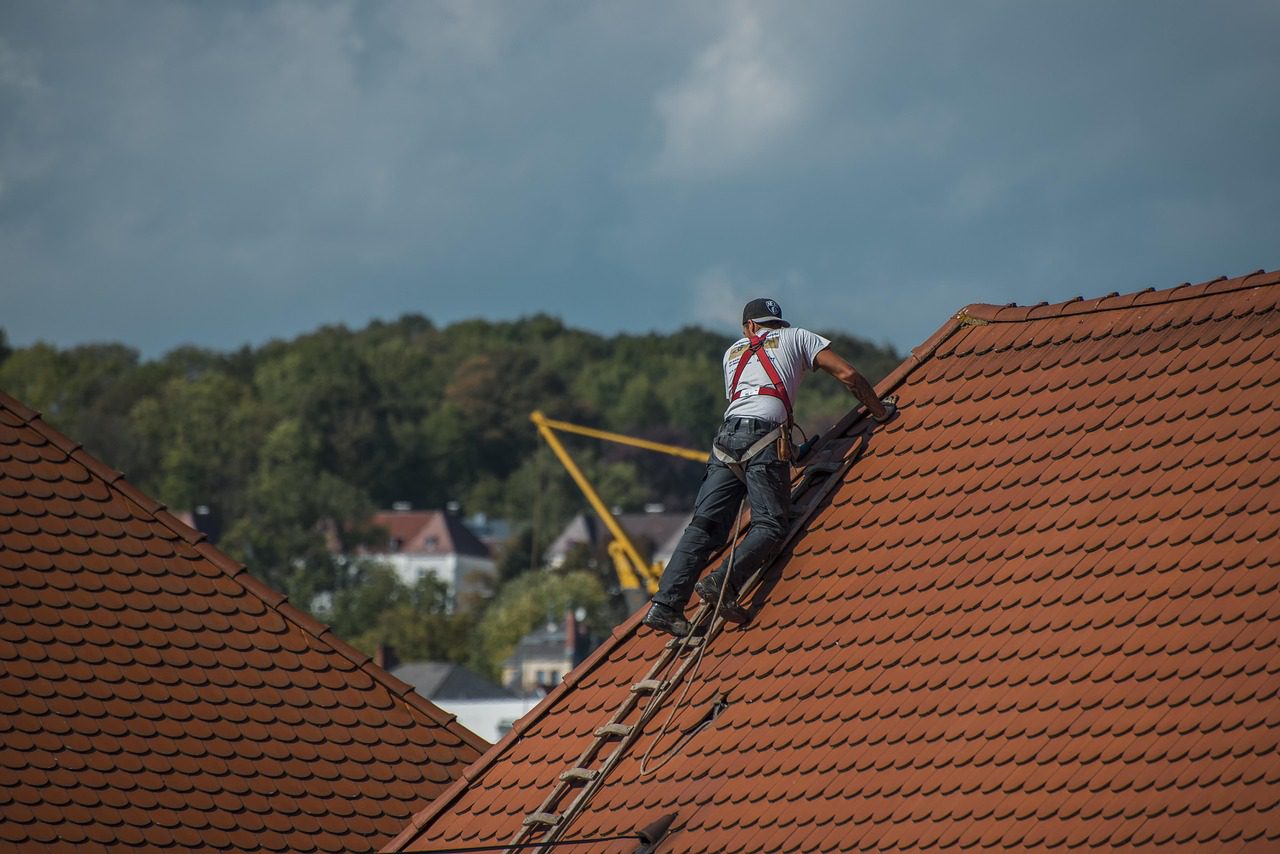 Roofing contractor inspecting roof leak damage